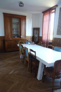 a dining room with a white table and chairs at Le Cœur d'Estourgie in Pionsat