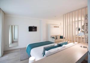 a white bedroom with a large bed and a mirror at Hotel Atlantiis Suites Near Kashi Vishwanath temple in Varanasi