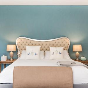a bedroom with a large bed with a blue wall at Hotel Atlantiis Suites Near Kashi Vishwanath temple in Varanasi +16 photos
