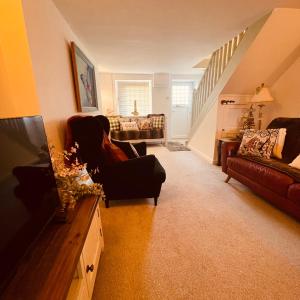 a living room with a couch and a television at Bear Cottage - Waterfall Country in Glyn Neath