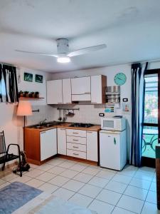 een keuken met witte kasten en witte apparaten bij Casa ARLECCHINA in Rio Marina