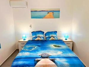 una camera da letto con un letto blu con vista sull'oceano di Belle petite maison Les Trois-Îlets a Les Trois-Îlets