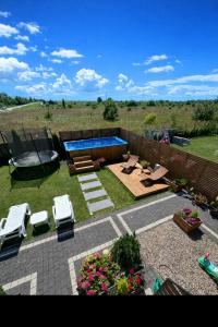 a backyard with a swimming pool and chairs and flowers at Holiday Amber - in Niechorze