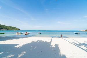 a shadow of a person on a beach with boats in the water at Dream Moon Hostel in Haad Rin