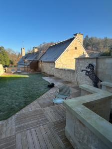 a wooden deck with a chair and a building at Résidence ARTHUS Cinopé in Pierrefonds