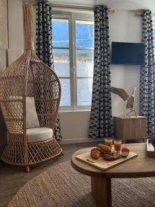 a living room with a table with a plate of food on it at Résidence ARTHUS Cinopé in Pierrefonds
