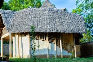 an old house with a thatched roof at Tropical lodge in Kakamega