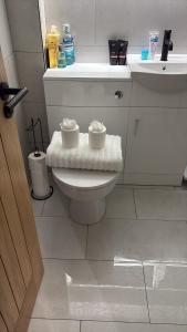 a bathroom with a toilet with two candles on it at Olivers retreat in Braintree