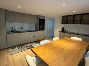 a kitchen with a wooden table and white chairs at Deine Auszeit mit Alpenblick in Kandergrund