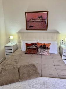 a bedroom with a large bed with two pillows at casa del sole Ossuccio in Como +13 photos