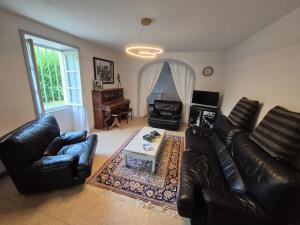 a living room with a leather couch and a table at Maison de Jules in Le Coteau