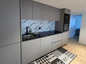 a kitchen with white cabinets and a sink at Deine Auszeit mit Alpenblick in Kandergrund +21 photos
