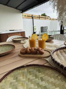 a wooden table with orange juice and donuts on it at Villa Canne & Ô in Saint-Joseph +5 photos