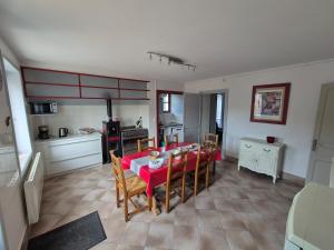 a kitchen and dining room with a red table and chairs at Maison de Jules in Le Coteau