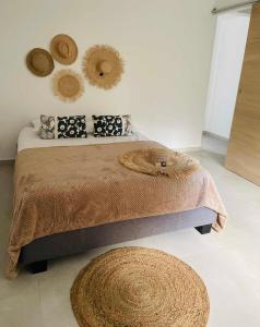 a bedroom with a bed with two hats on the wall at Villa Canne & Ô in Saint-Joseph
