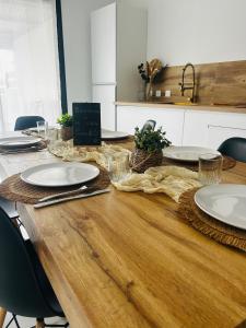 a wooden table with plates on top of it at Villa Canne & Ô in Saint-Joseph
