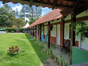 a building with a yard with a bench and plants at Pousada Casa de Campo in Conservatória