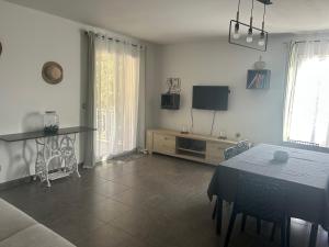 un soggiorno con un tavolo e una tv di Bel appart - 3 ch Vallon pont d 'arc a Salavas