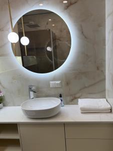 un bagno bianco con lavandino e specchio di Apartment Uman a Umanʼ