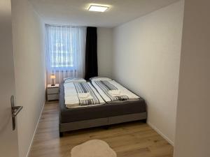 a bed in a small room with a window at Deine Auszeit mit Alpenblick in Kandergrund