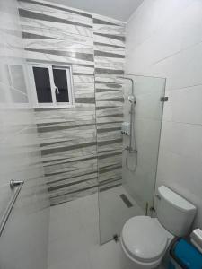 a bathroom with a toilet and a glass shower at Byk in Nagua +19 photos