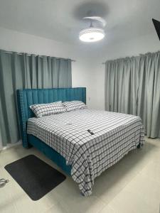 a bedroom with a bed with a blue head board at Byk in Nagua
