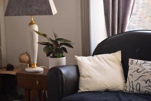 a chair with a pillow and a lamp on a table at La Villa Côté Cour in Dinan