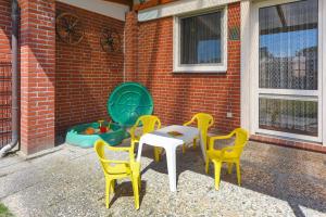 a table and four chairs with a table and a play area at Ferienhaus Wolke 7 in Bensersiel