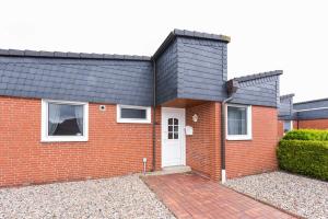 a red brick house with a black roof at Ferienhaus Wolke 7 in Bensersiel +49 photos