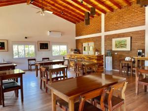 een eetkamer met houten tafels en stoelen bij Posada del Manzano in Carpintería
