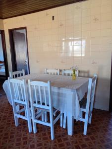 a white table with white chairs and a blue tablecloth at Aluguel de Temporada in Arroio do Sal