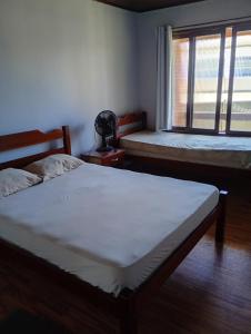 a bedroom with two beds and a window at Aluguel de Temporada in Arroio do Sal
