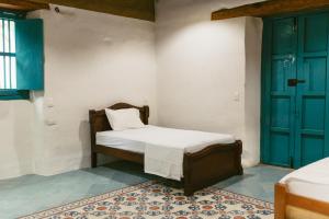 a bedroom with a bed and a blue door at Posada Los Tres Arrieros in Jordán +6 photos