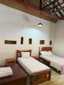 a room with two beds and a table at Posada Los Tres Arrieros in Jordán