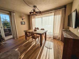 un tavolo da pranzo con sedie e una grande finestra di Alpine Apartments St-Sigmund a Sankt Sigmund im Sellrain