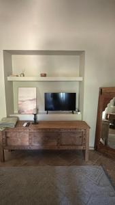 a living room with a tv and a wooden coffee table at Orange Garden in Himare