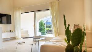 a living room with a couch and a cactus at Villa Sara - Porto Cervo - 2 Private Beaches & Garden - by Coral Property in Porto Cervo