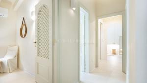 a hallway with a white door and a white floor at Villa Sara - Porto Cervo - 2 Private Beaches & Garden - by Coral Property in Porto Cervo +19 photos