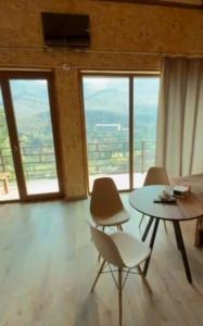a living room with a table and chairs and windows at Green Paradise in Ijevan +29 photos