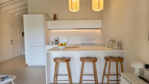 a kitchen with a counter and stools in a kitchen at Villa Sara - Porto Cervo - 2 Private Beaches & Garden - by Coral Property in Porto Cervo
