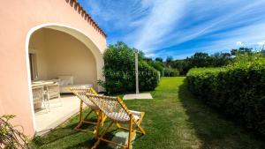 a pair of chairs sitting on a lawn next to a house at Villa Sara - Porto Cervo - 2 Private Beaches & Garden - by Coral Property in Porto Cervo
