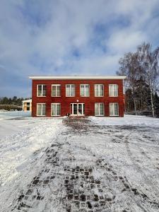 een rood bakstenen gebouw met sneeuw ervoor bij Schüler & Simon GbR "Kleine Landvilla" in Meuro
