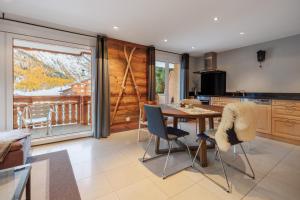 a kitchen with a table and chairs and a balcony at Cornelia in Saas-Fee