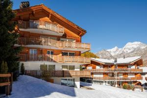 a ski lodge in the mountains with snow on the ground at Cornelia in Saas-Fee