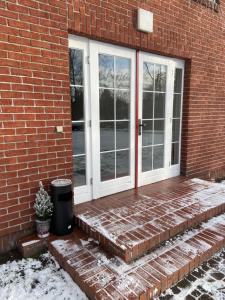 een voordeur van een bakstenen huis met een potplant bij Schüler & Simon GbR "Kleine Landvilla" in Meuro