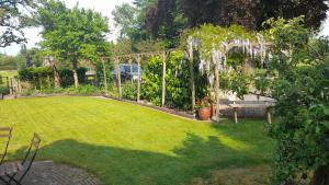a garden with a pergola and a bench in a yard at De Veldhoeve in Apeldoorn