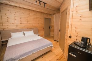 una camera da letto con un letto in una parete di legno di Kvirike Hills Hotel a Kobuleti Altre 2 foto