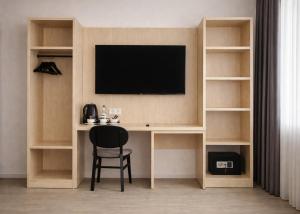 een bureau met een tv en een stoel in een kamer bij Niko Hotel am Hannover Hbf in Hannover +26 foto's