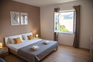 a bedroom with a bed with two towels on it at Apartmani Nana Mija in Pag