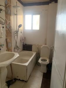a bathroom with a tub and a toilet and a sink at Simple gem in port said in Port Said +10 photos